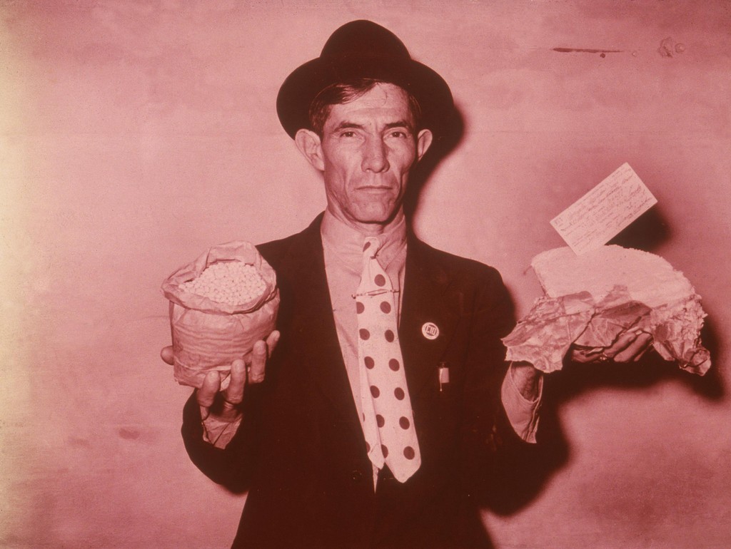 Pecan worker displaying relief supplies that are meant to last 3 weeks (1939)