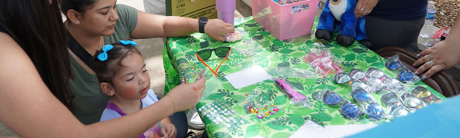 Family decorating sunglasses at Discover TAMIU 2024
