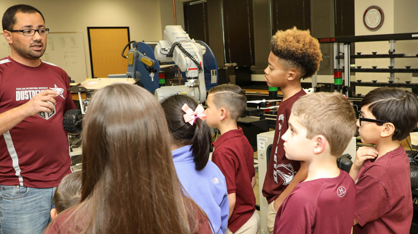 A University teaching a group of young students about robotics.
